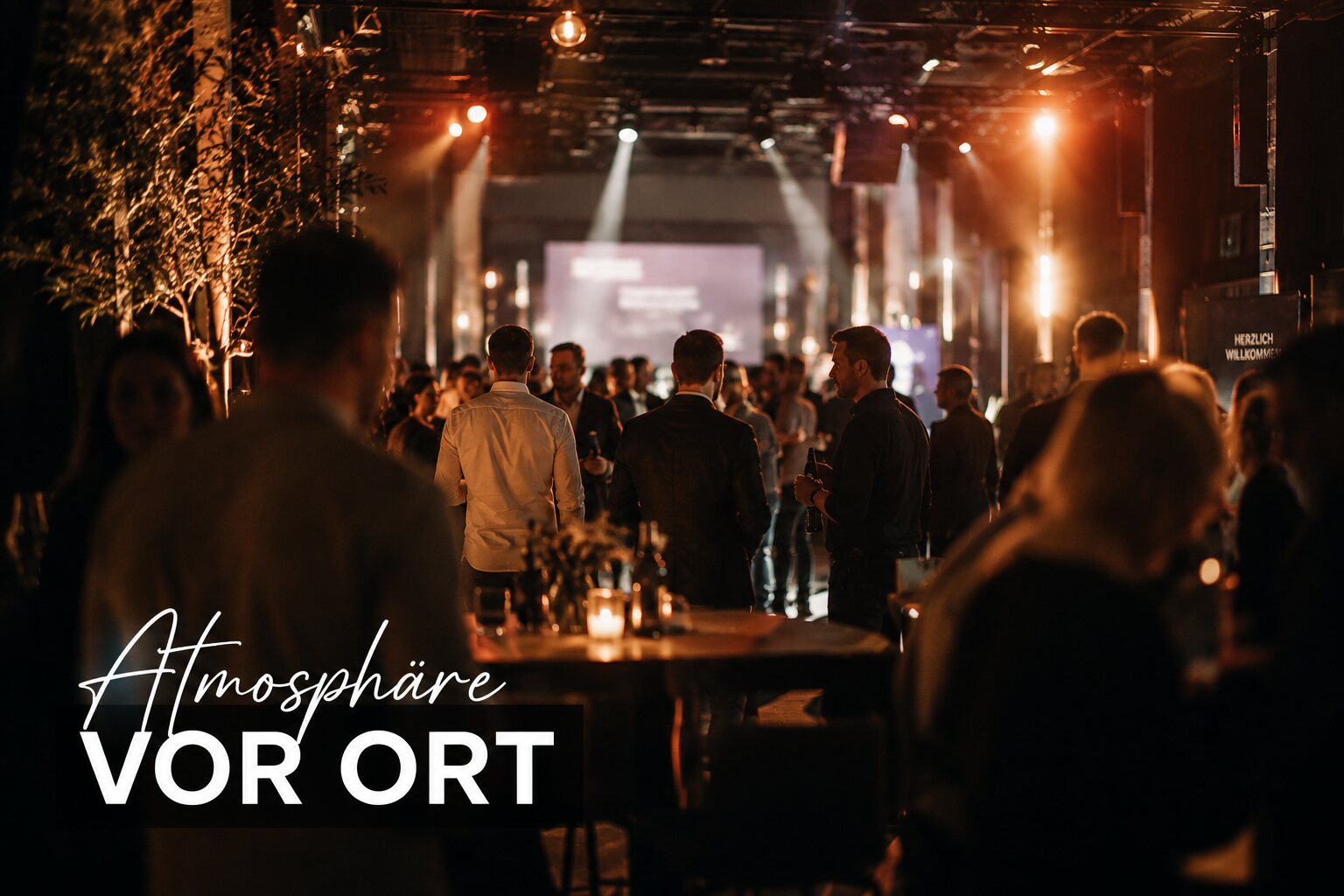 Stimmungsvolle Atmosphäre bei einem Event: Gäste und warmes Bühnenlicht