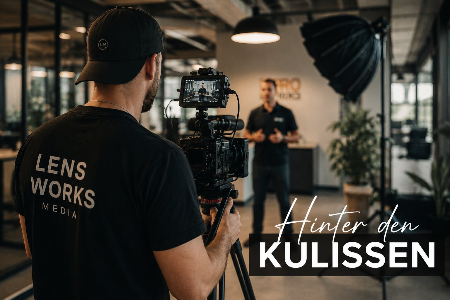Behind-the-Scenes vom Business-Content-Dreh: Kamera im Vordergrund, Mitarbeiter im Office im Hintergrund